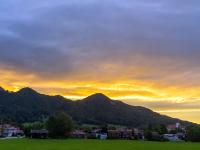 Gelborange leuchtende Abendwolken über den Aschauer Bergen